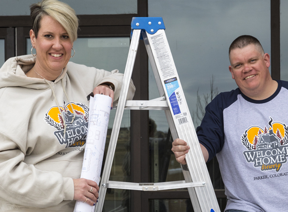 welcome home owners standing by ladder