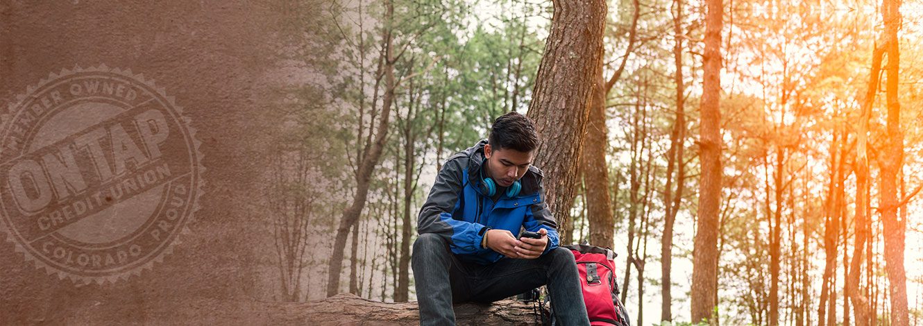 man in woods on mobile device