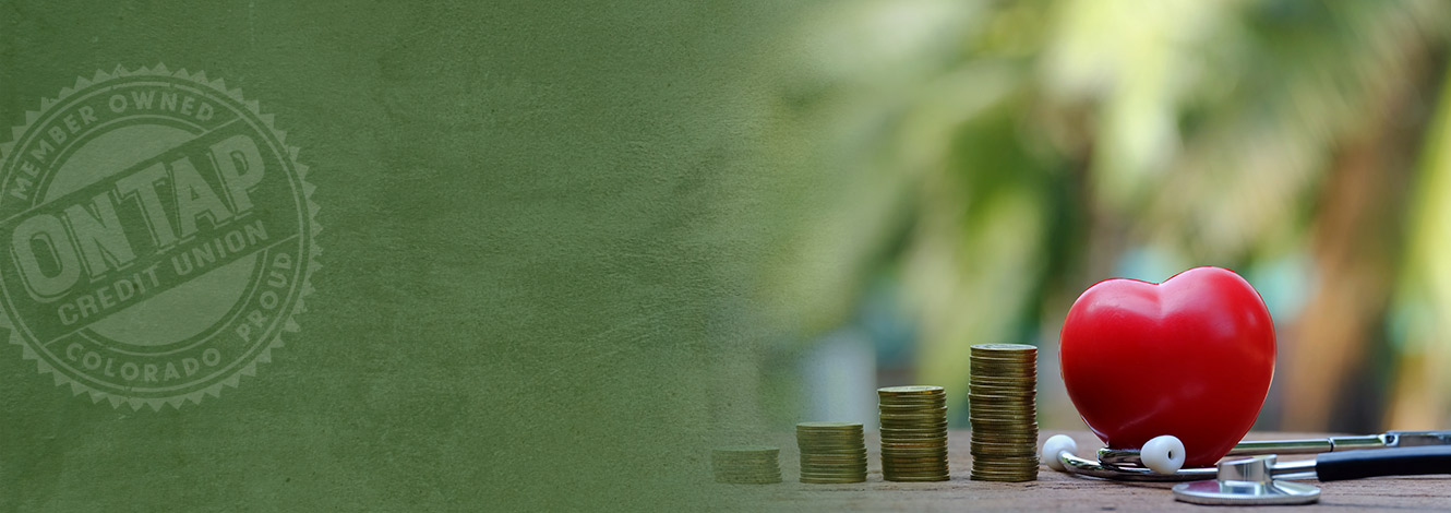 photo of stacks of change, plastic heart and stethoscope