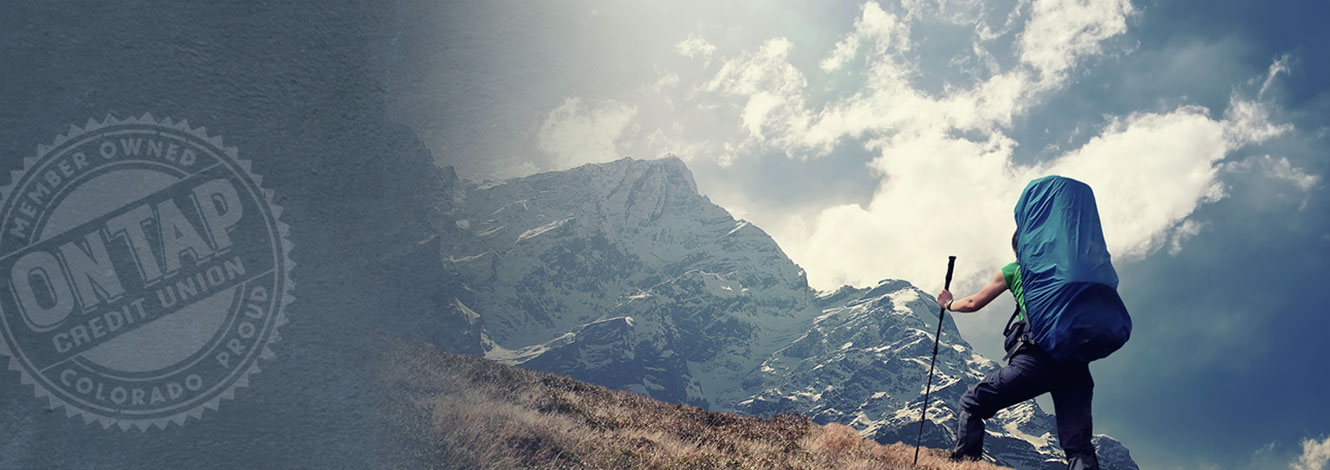 person climbing mountain with backpack