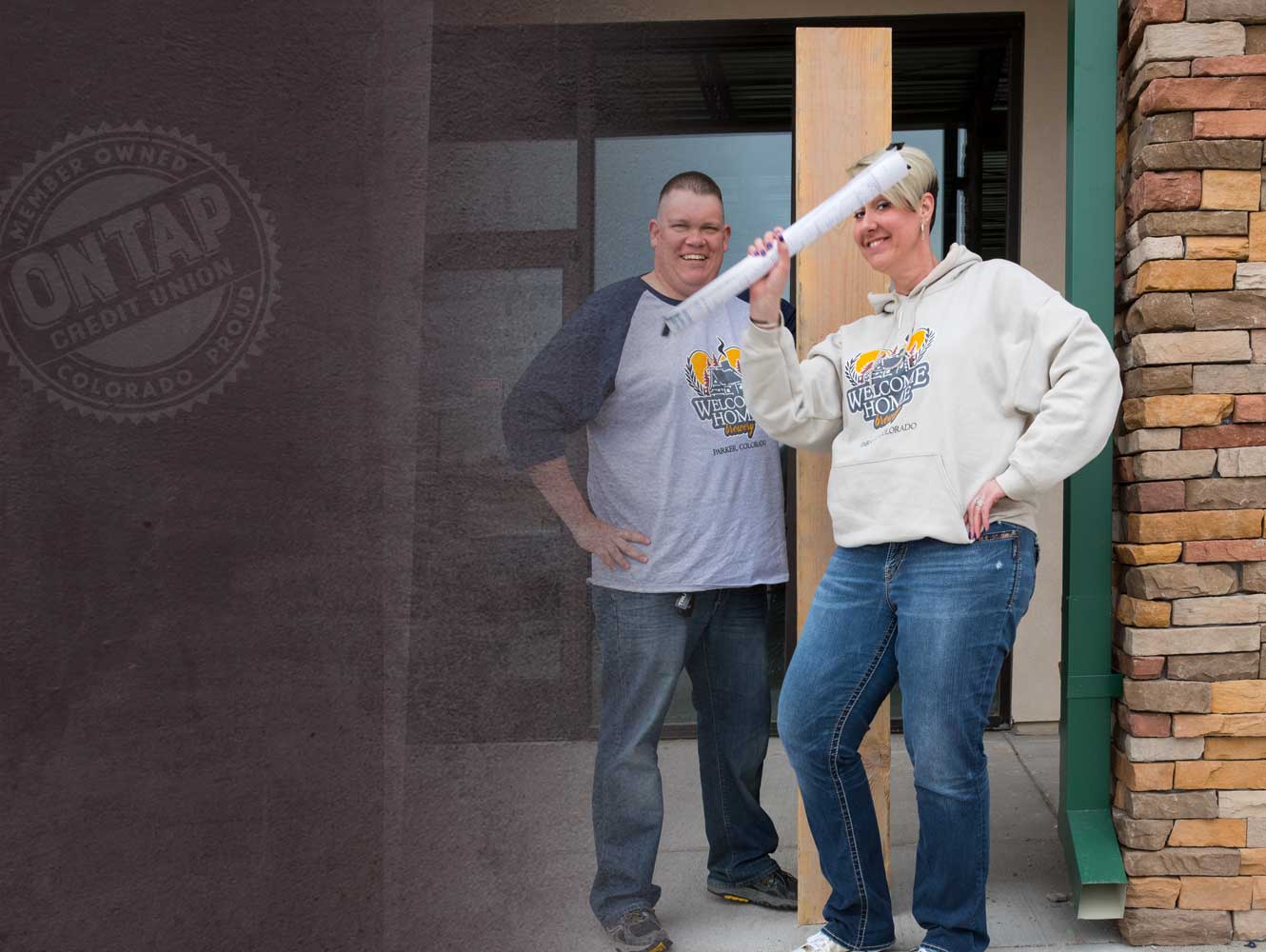 welcome home owners standing in front of build site