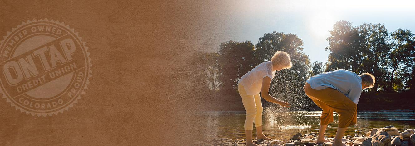 older couple skipping rocks in stream