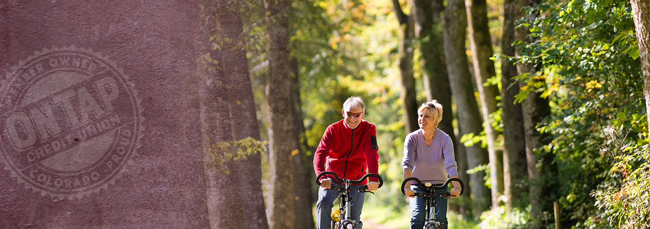 older couple biking in wilderness